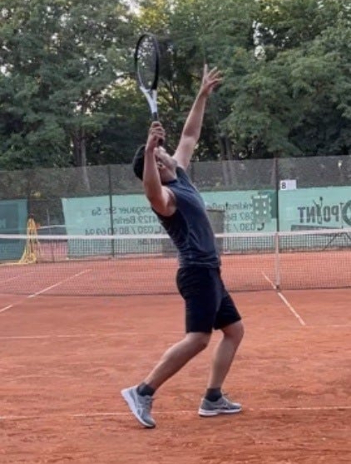 Tennis player serving on a clay court